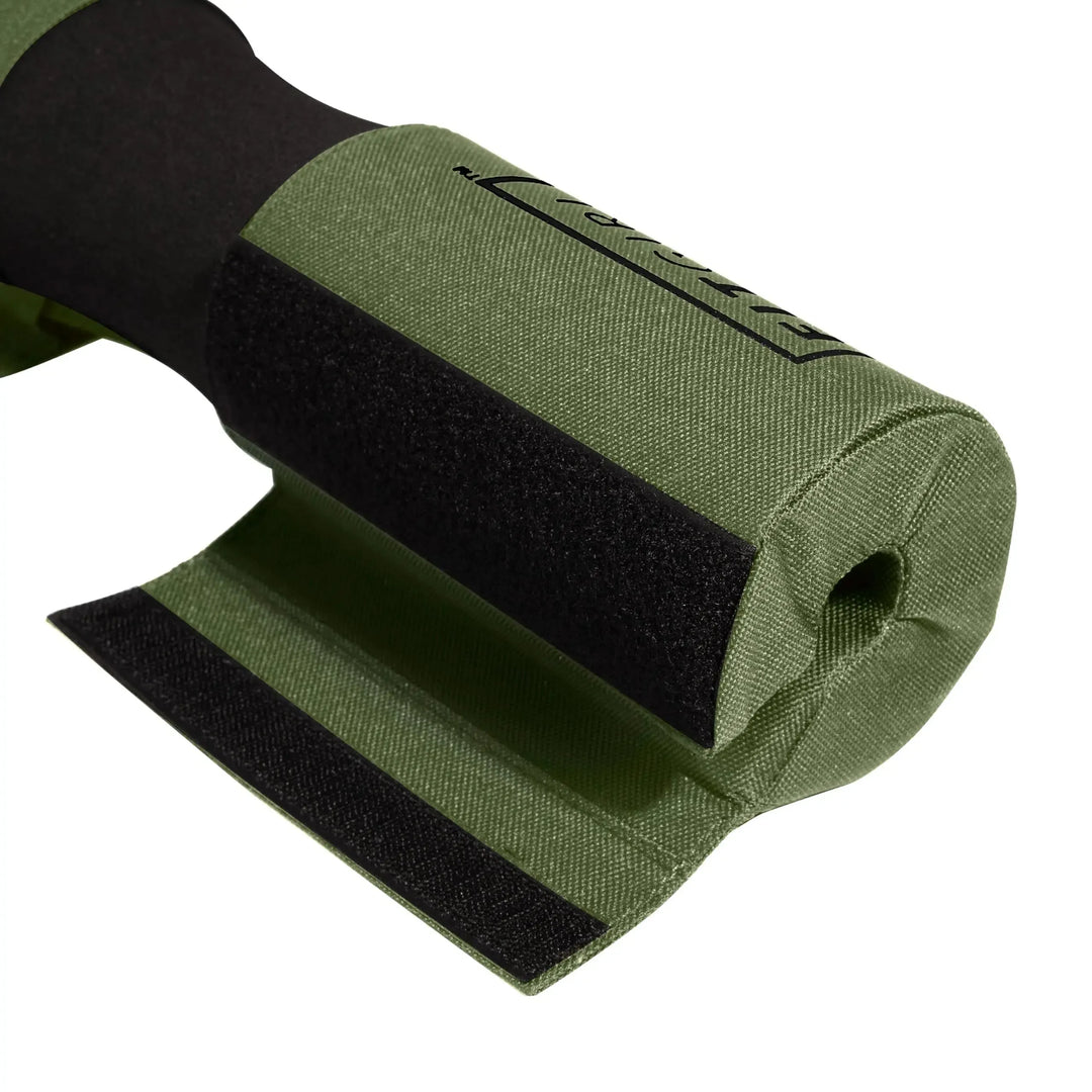 Close-up of a rolled FITGIRL Squat & Hip Thrust Barbell Pad: green fabric with a black loop and thick foam cushioning, designed for women. Includes Velcro strip; partially open end reveals material texture and weave.
