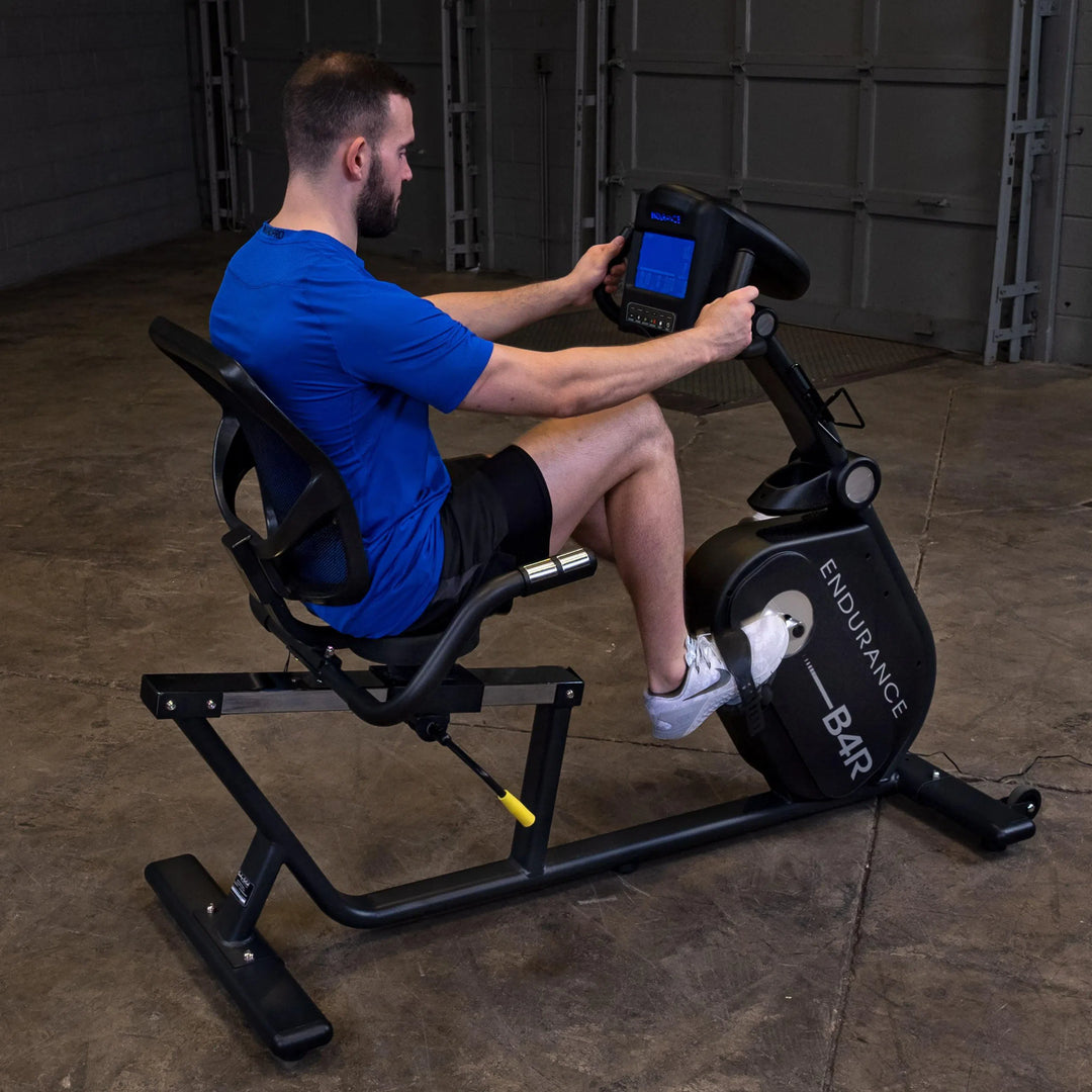 A man training on the Body Solid Endurance Commercial Recumbent Bike B4RB