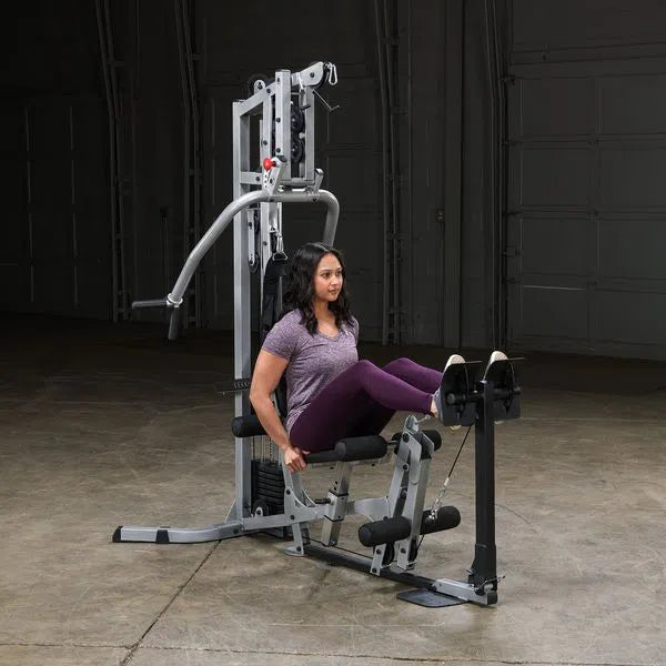 A woman training her legs on the Body-Solid Powerline Home Gym with Leg Press