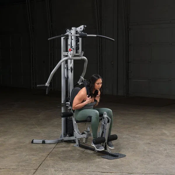 A woman doing ab crunches on the Body-Solid Powerline Home Gym with Leg Press