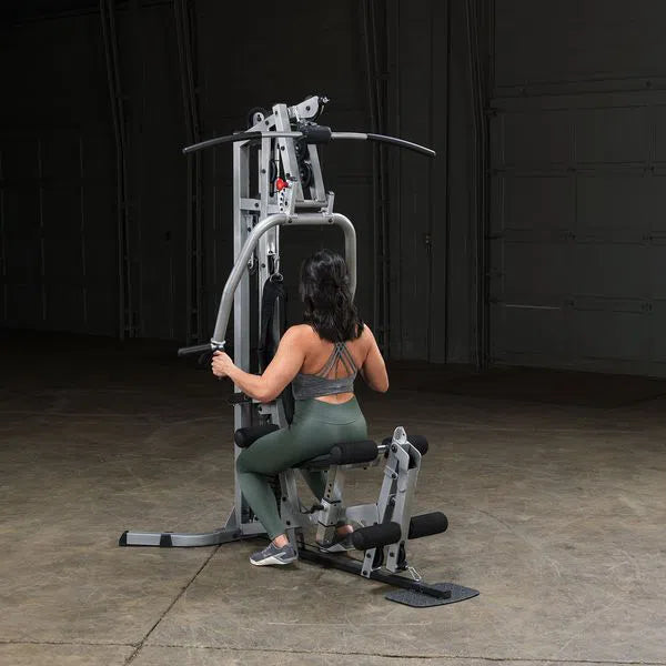 A woman doing back rows on the Body-Solid Powerline Home Gym with Leg Press