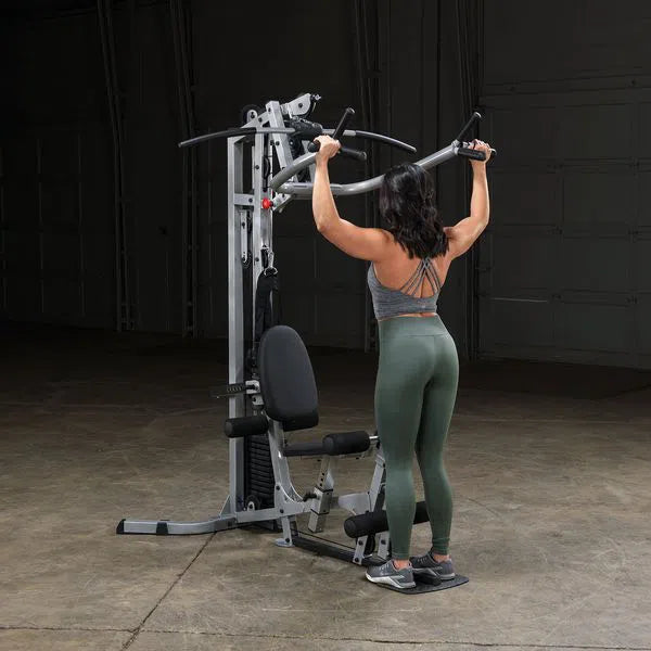 A woman training back on the Body-Solid Powerline Home Gym with Leg Press