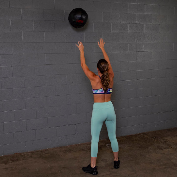 A woman training with the Body-Solid Dynamax Wall Ball BSTDYN