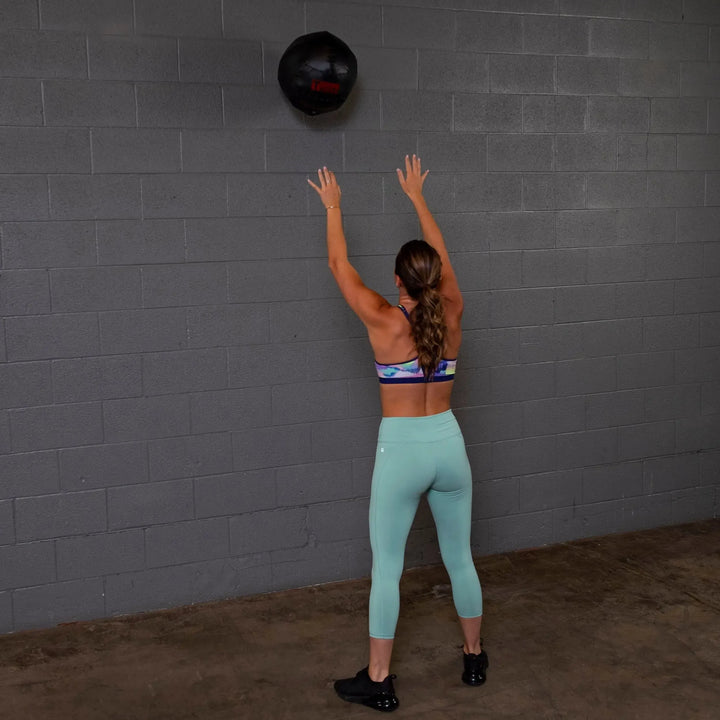 A woman training with the Body-Solid Dynamax Wall Ball BSTDYN