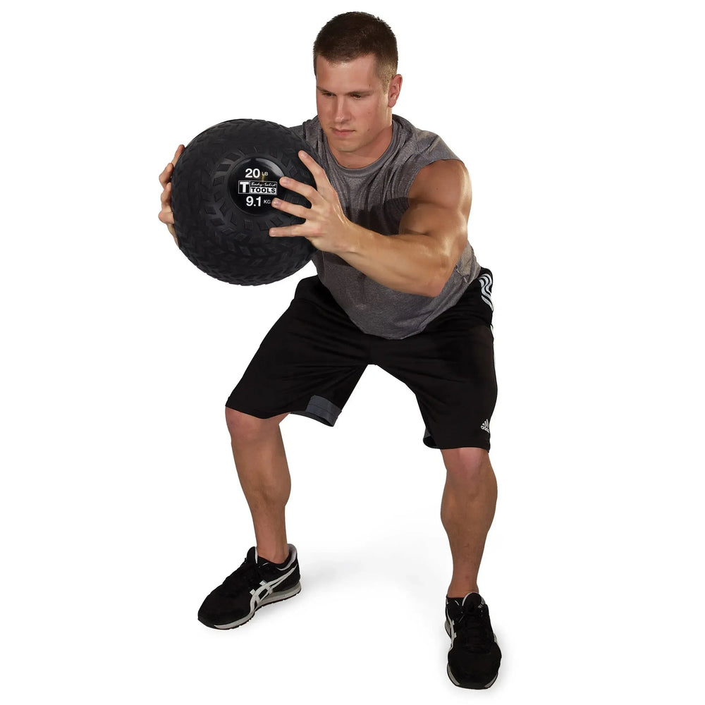 A man training with a Body-Solid Tire Tread Slam Ball BSTTT