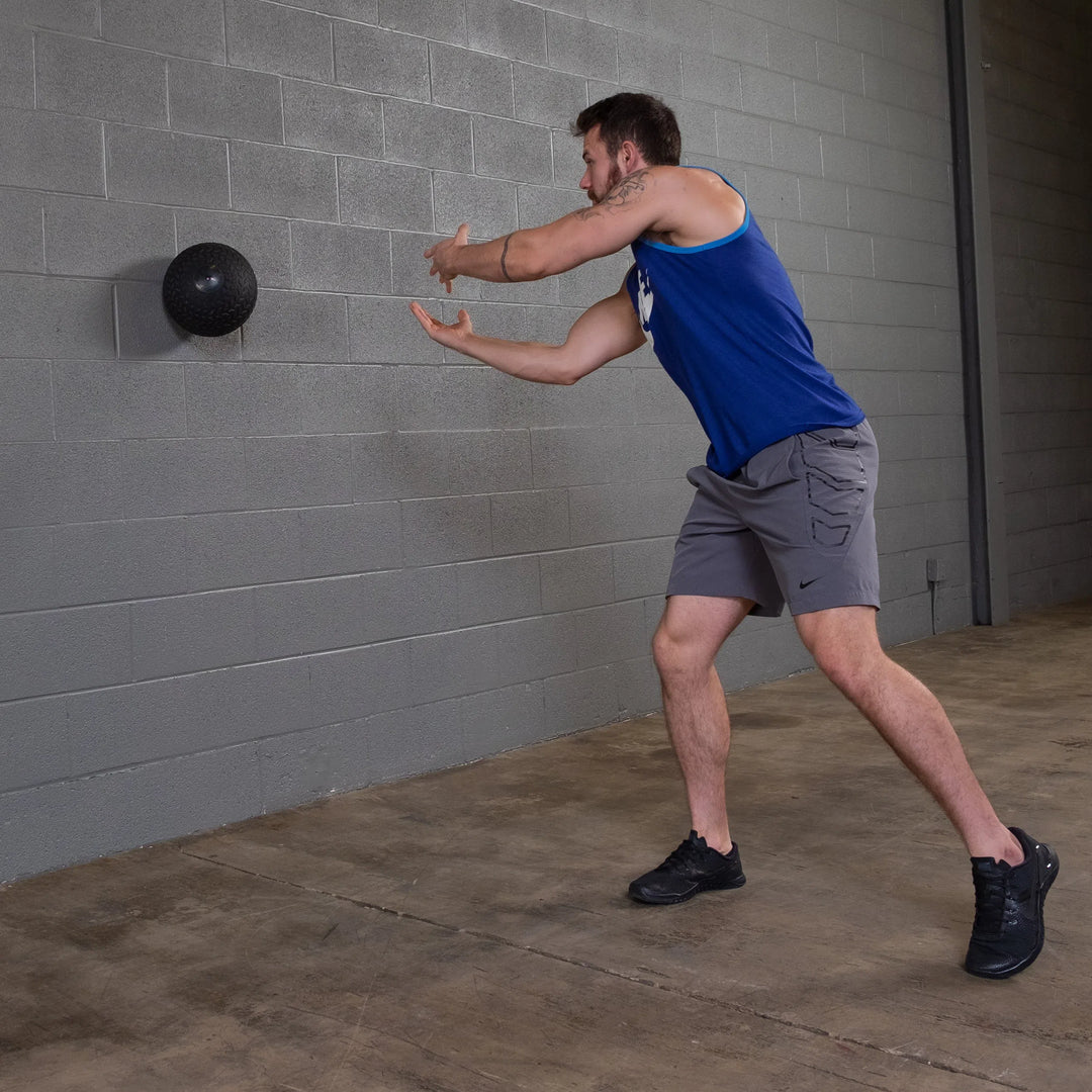 A man training with a Body-Solid Tire Tread Slam Ball BSTTT