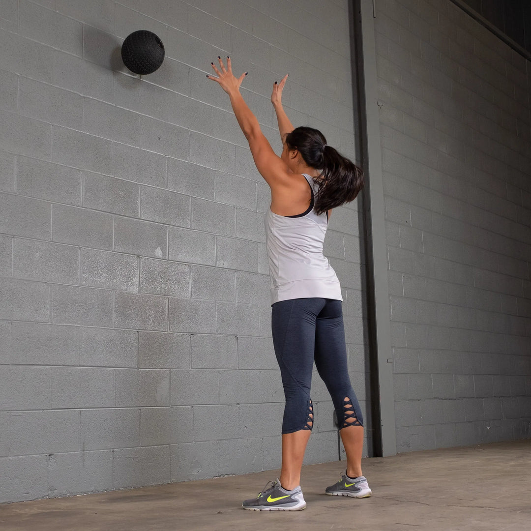 girl tossing the Body-Solid Tire Tread Slam Ball BSTTT