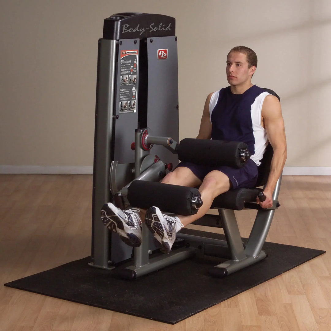 A man training on the Body-Solid Leg Extension Leg Curl Combo Machine DLECSF
