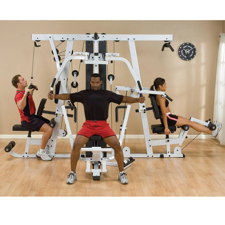 A group of three training together on the Body-Solid Universal Weight Machine with Leg Press EXM4000S