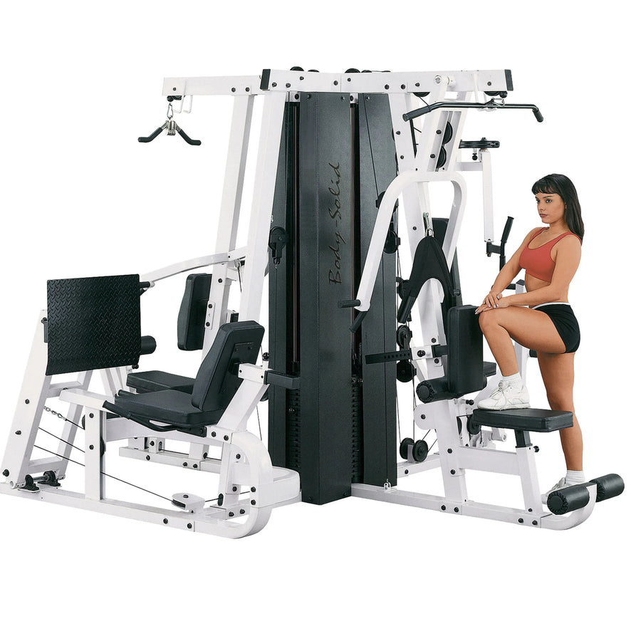 A woman showcasing the Body-Solid Universal Weight Machine with Leg Press EXM4000S