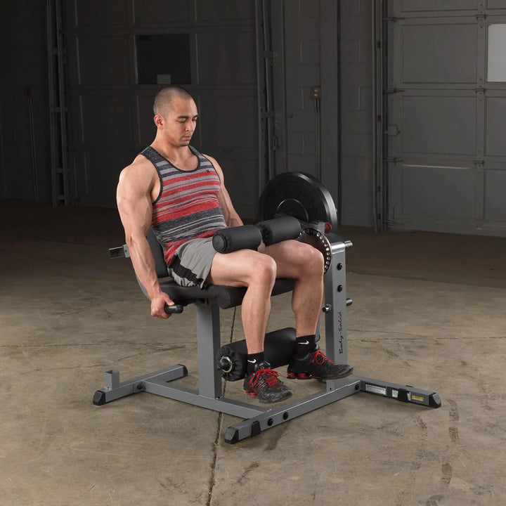 A man training on the Body-Solid Leg Extension and Curl Machine GCEC340