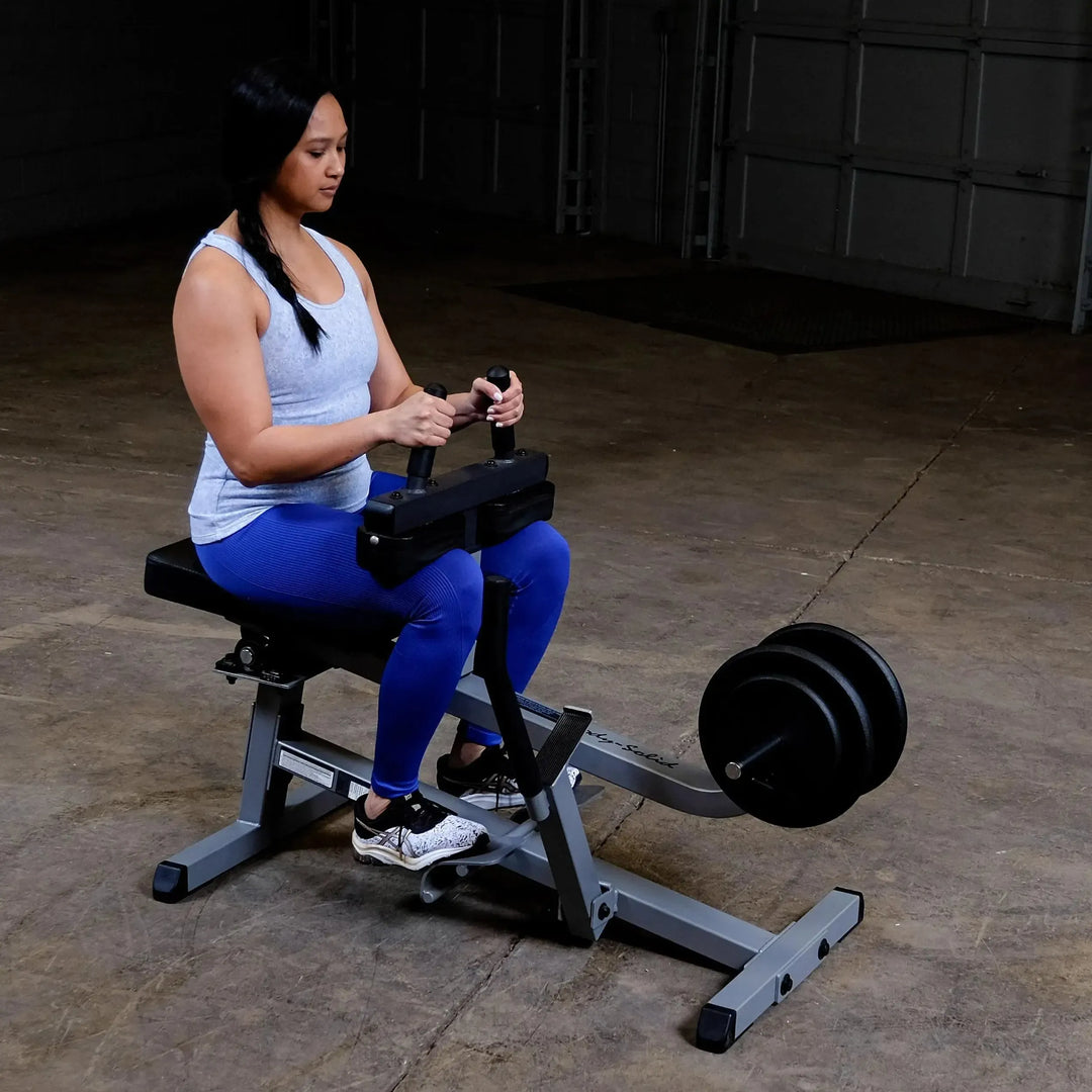 A woman training on the Body-Solid Calf Raise Machine GSCR349