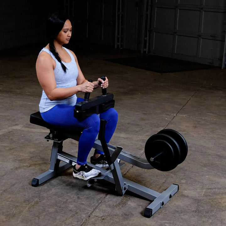 A woman training on the Body-Solid Calf Raise Machine GSCR349