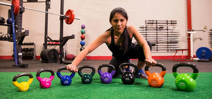 A woman showcasing the Body-Solid Vinyl Kettlebell Set KBV