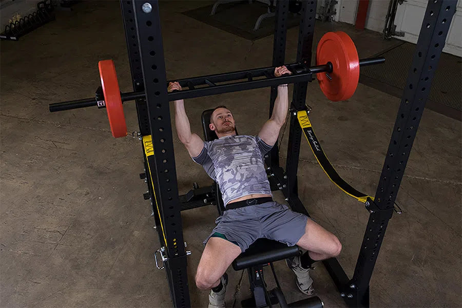 A man training with the Body-Solid Multi Grip Bench Press Bar OMG86