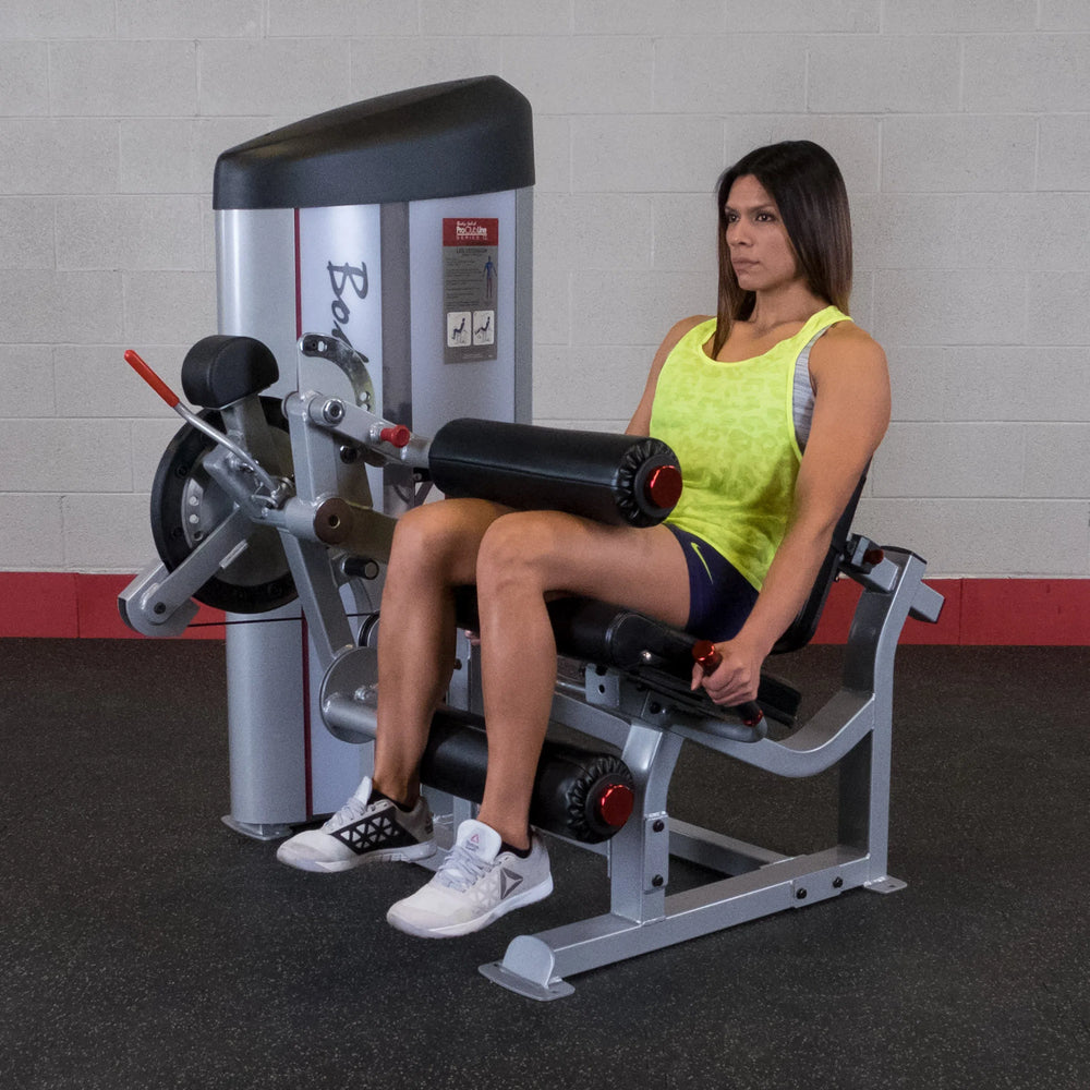 A woman training on the Body-Solid Leg Curl and Extension Machine S2LEC