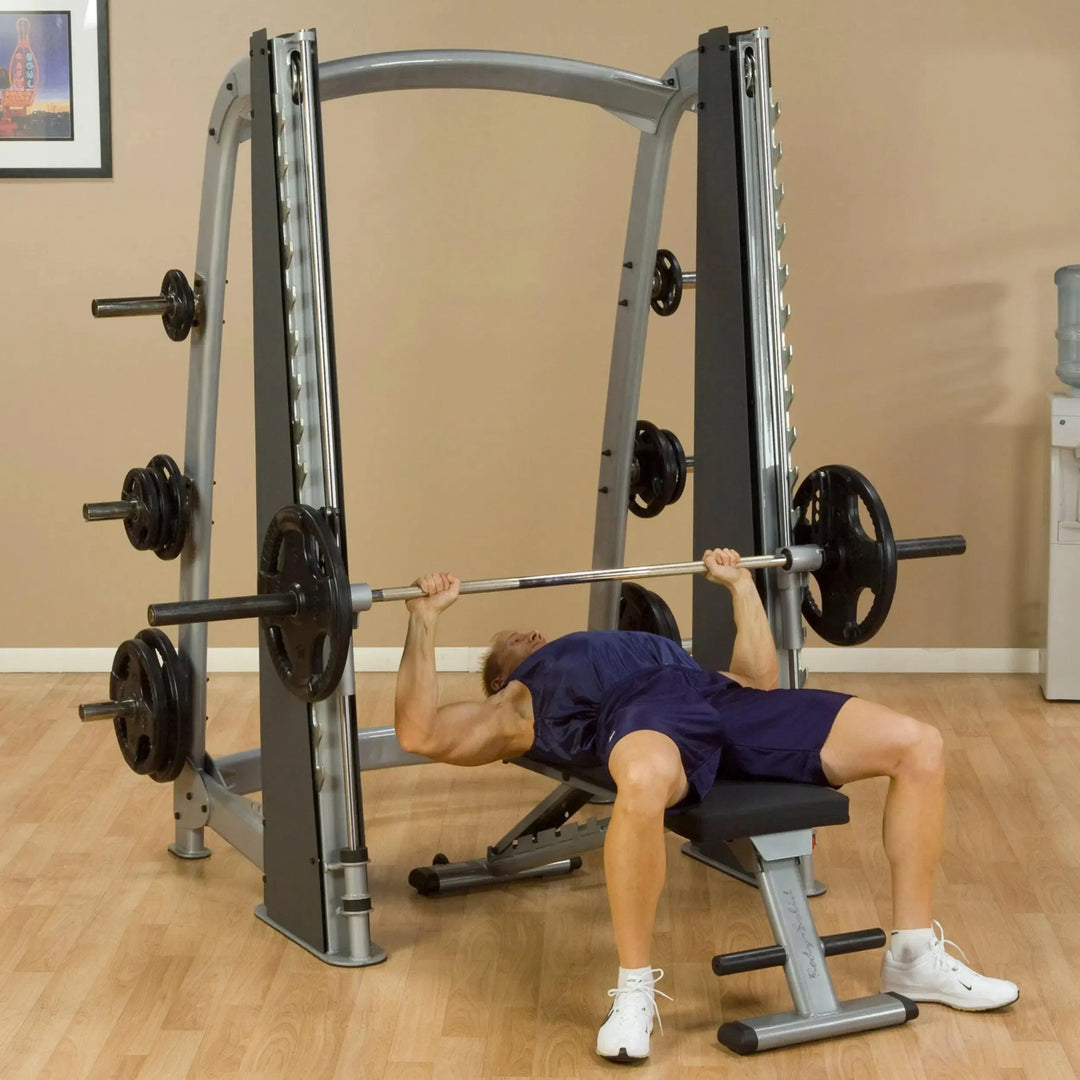 A man doing flat bench presses on the Body-Solid Commercial Smith Machine SCB1000