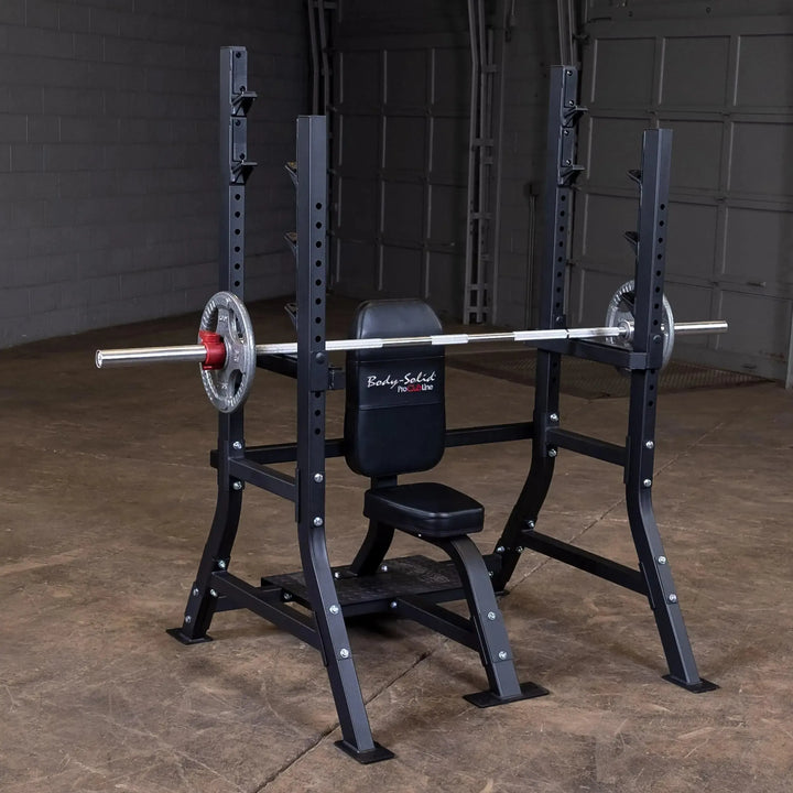 The Body-Solid Pro Clubline Olympic Shoulder Press Bench (SOSB250) features a durable steel mainframe, a black padded seat and backrest, and a metal rack with adjustable safety stops. It stands in an empty room against gray walls with a garage-style door.