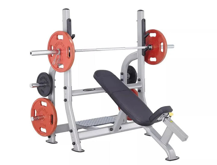 The SteelFlex Olympic Incline Bench (NOIB) by Steelflex features red and black weight plates on a barbell, designed for pectoralis exercises. With a black padded seat and solid silver frame, its ideal for boosting gym performance in weightlifting workouts.
