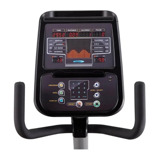 Close-up of the SteelFlex Commercial Recumbent Bike (PR10) display showcases time, distance, calories, and pulse metrics. The Steelflex equipment features program selection and resistance buttons, with black handlebars framing its elegant dashboard.