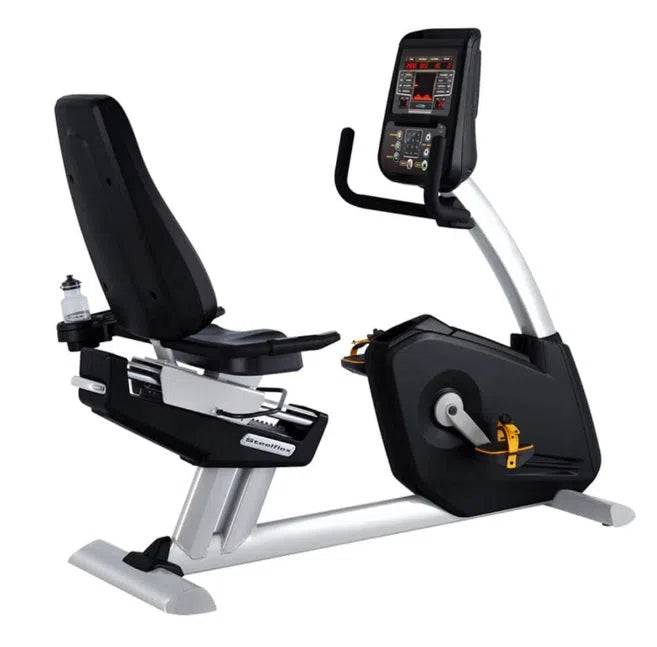 The SteelFlex Commercial Recumbent Bike (PR10) by Steelflex is a premium fitness solution featuring a sleek silver frame, black cushioned seat, digital display, pedals, and a water bottle holder for an optimal gym experience.