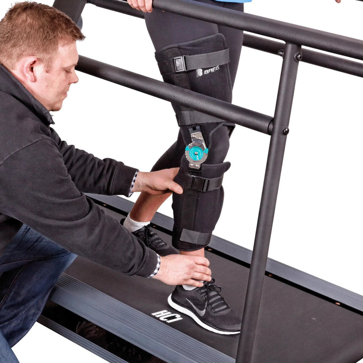 A coach assisting a woman undergoing therapy training on the HCI PhysioMill 500 lb. User Heavy Duty Treadmill TMR