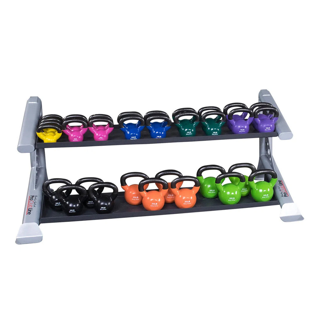 The Body-Solid Pro Clubline Storage Rack w/ Kettlebell Tiers is a sturdy heavy-gauge steel rack holding colorful kettlebells. The top tier features weights in yellow, pink, blue, black, and orange; the bottom tier displays black, orange, green, and blue. Each kettlebell is clearly weight-labeled for easy selection.