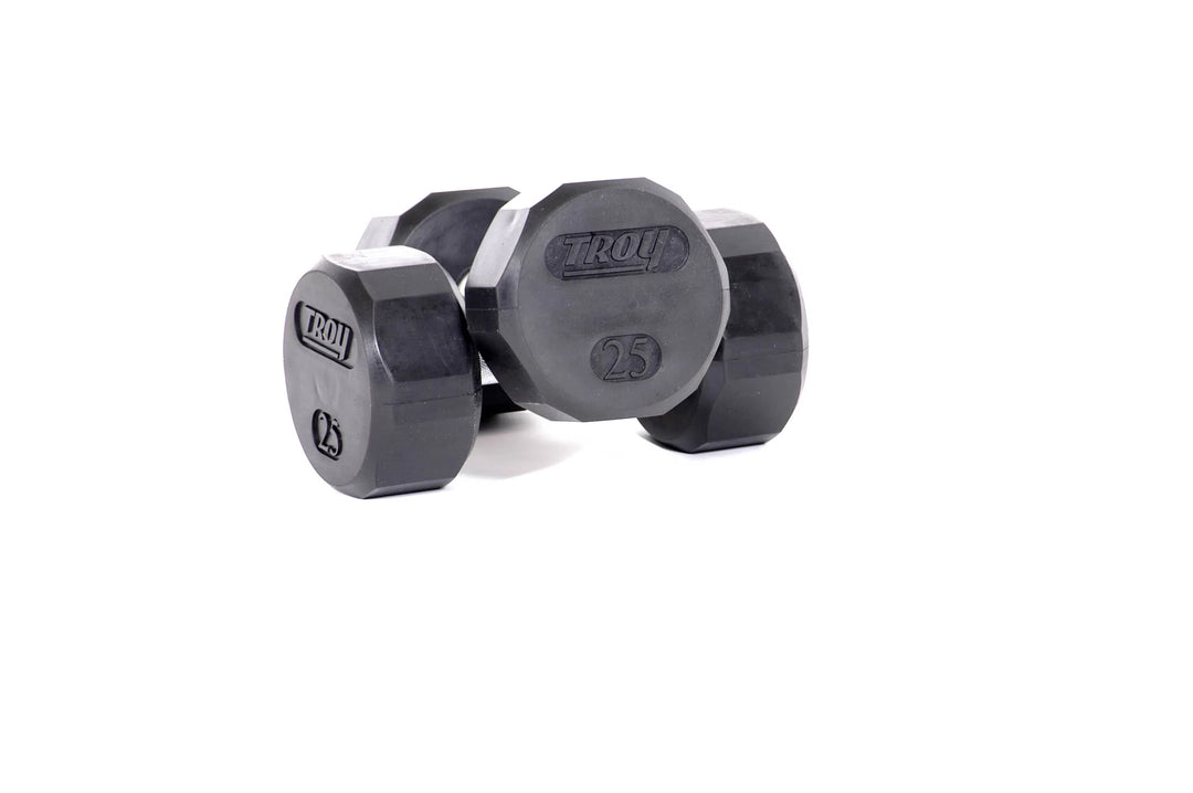 Two black 25-pound hexagonal dumbbells, engraved with Troy and 25, from the Troy 5-50 lb Rubber Commercial Dumbbell Set by TROY Barbell, sit against a plain white background.