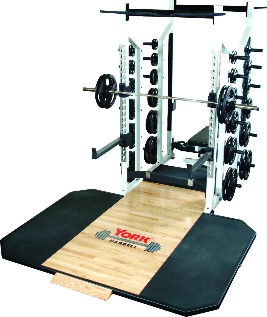 A York STS Double Half Rack by York Barbell sits on a wooden weightlifting platform bordered by black rubber mats, perfect for strength training. Barbell plates are neatly stored at the sides, and the platform features the York logo with a barbell insignia.