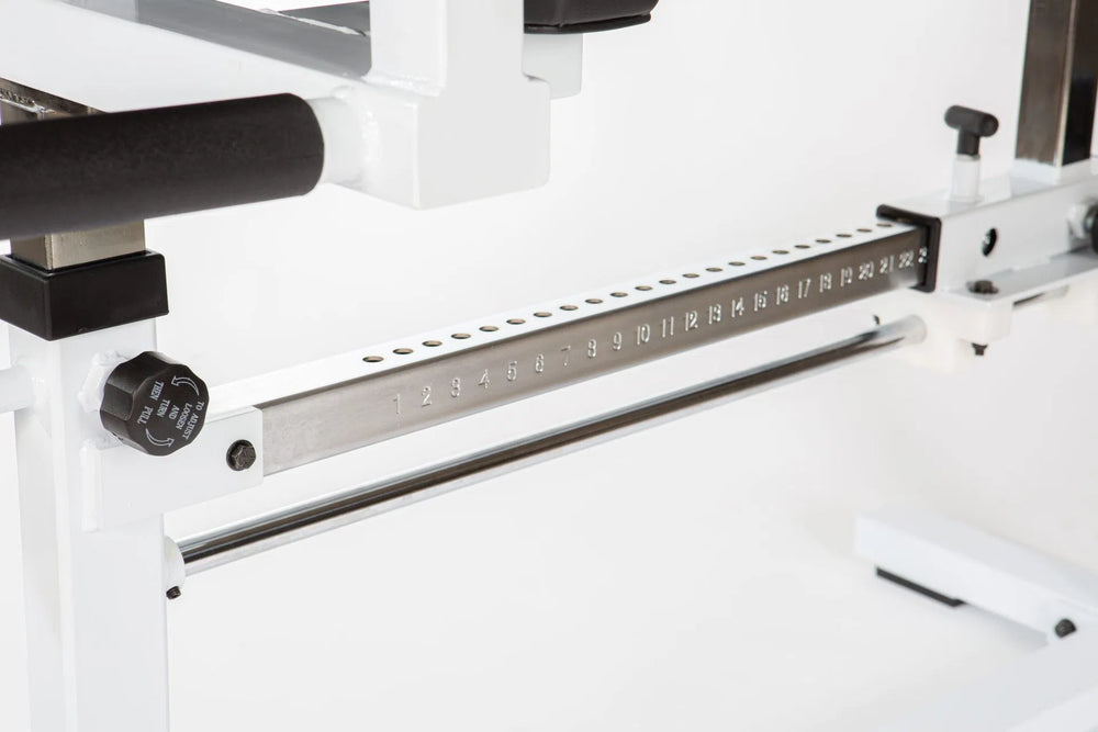 The York STS Glute Ham Developer Machine by York Barbell features a close-up of its mechanism, showcasing a metal rod with numbered holes from 1 to 33. A black knob on the left side is labeled for adjustments. The structure is predominantly white and metallic, ideal for advanced training.
