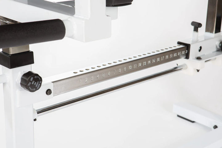 The York STS Glute Ham Developer Machine by York Barbell features a close-up of its mechanism, showcasing a metal rod with numbered holes from 1 to 33. A black knob on the left side is labeled for adjustments. The structure is predominantly white and metallic, ideal for advanced training.