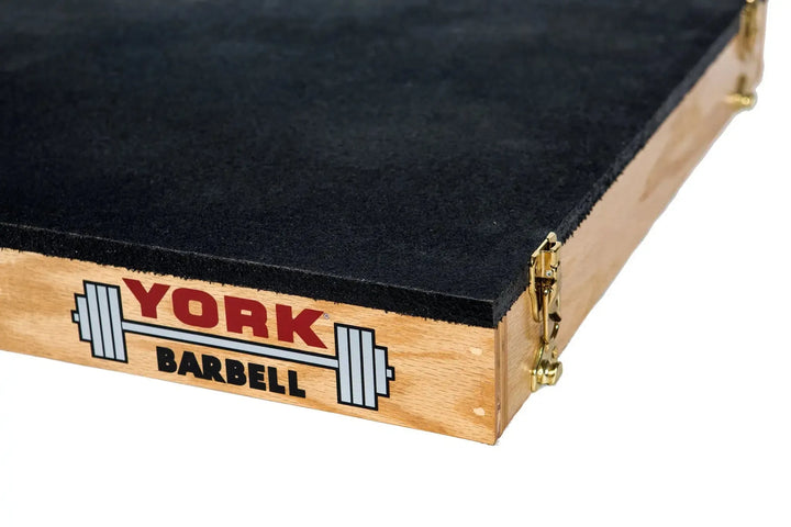 Close-up of the York Stackable Plyo / Step-Up Box with a black rubber top, ideal for high-intensity workouts. The York Barbell logo features a barbell image, and metal-reinforced corners enhance its durability, making it robust fitness equipment for your gym.