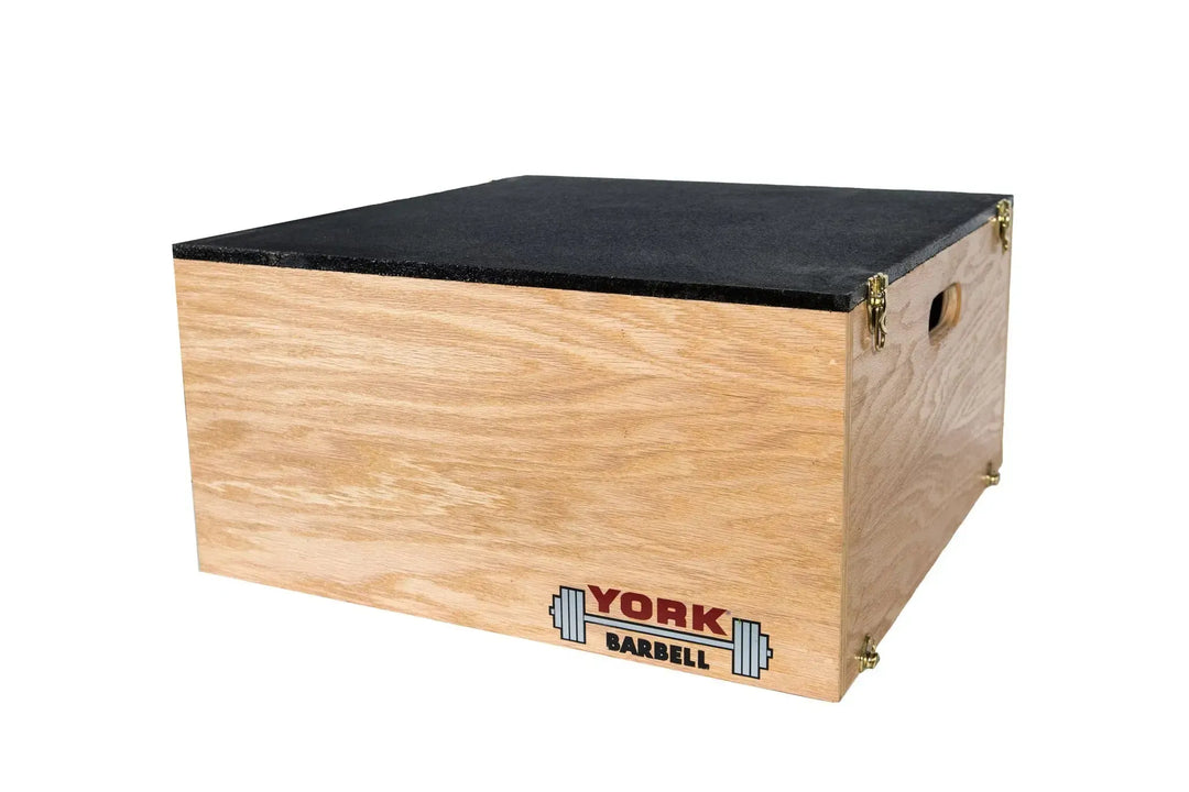 The York Stackable Plyo / Step-Up Box features a black top and side handles, ideal for high-intensity workouts. The York Barbell logo with a barbell illustration adorns the front, making it a perfect addition to your fitness gear.