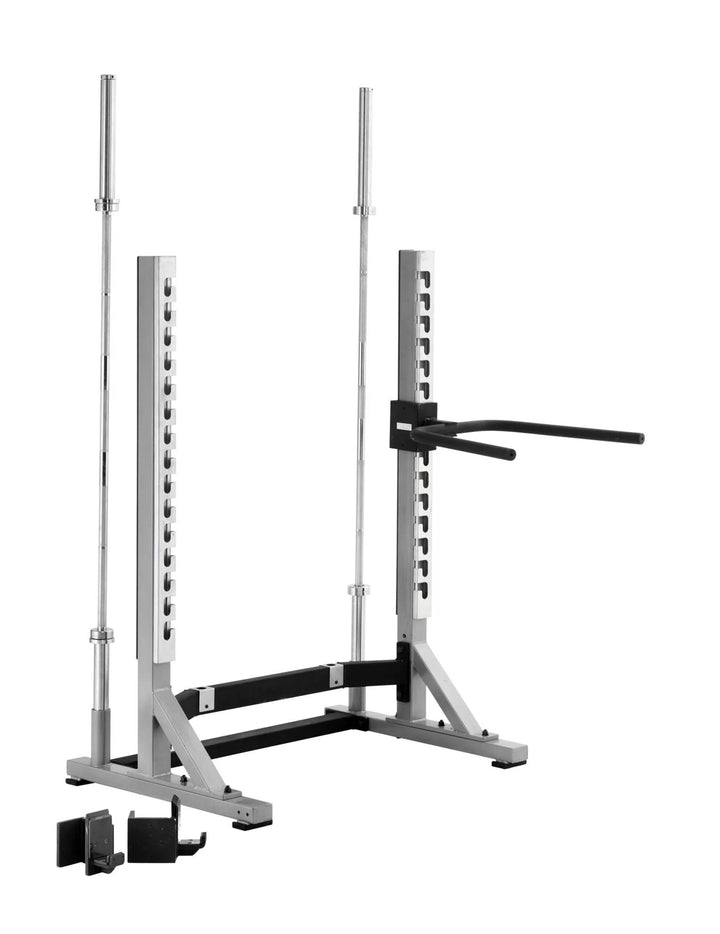 The York Barbell STS Collegiate Squat Rack, featuring a compact design, silver adjustable J-hooks, safety bars, and extended dip bars, stands out against a clear white floor in the gym.