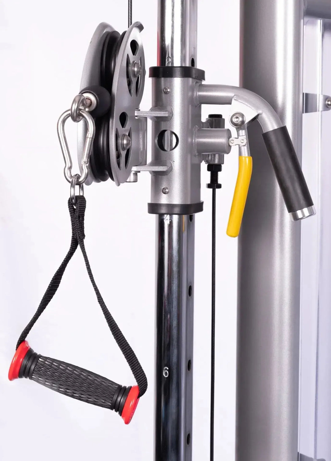 Close-up of the York STS Functional Cable Crossover Machine by York Barbell, showcasing its black and red handle. The metal pole features a numbered height marker, and the pulley system includes a yellow tension-adjusting lever, ideal for functional strength training enthusiasts.