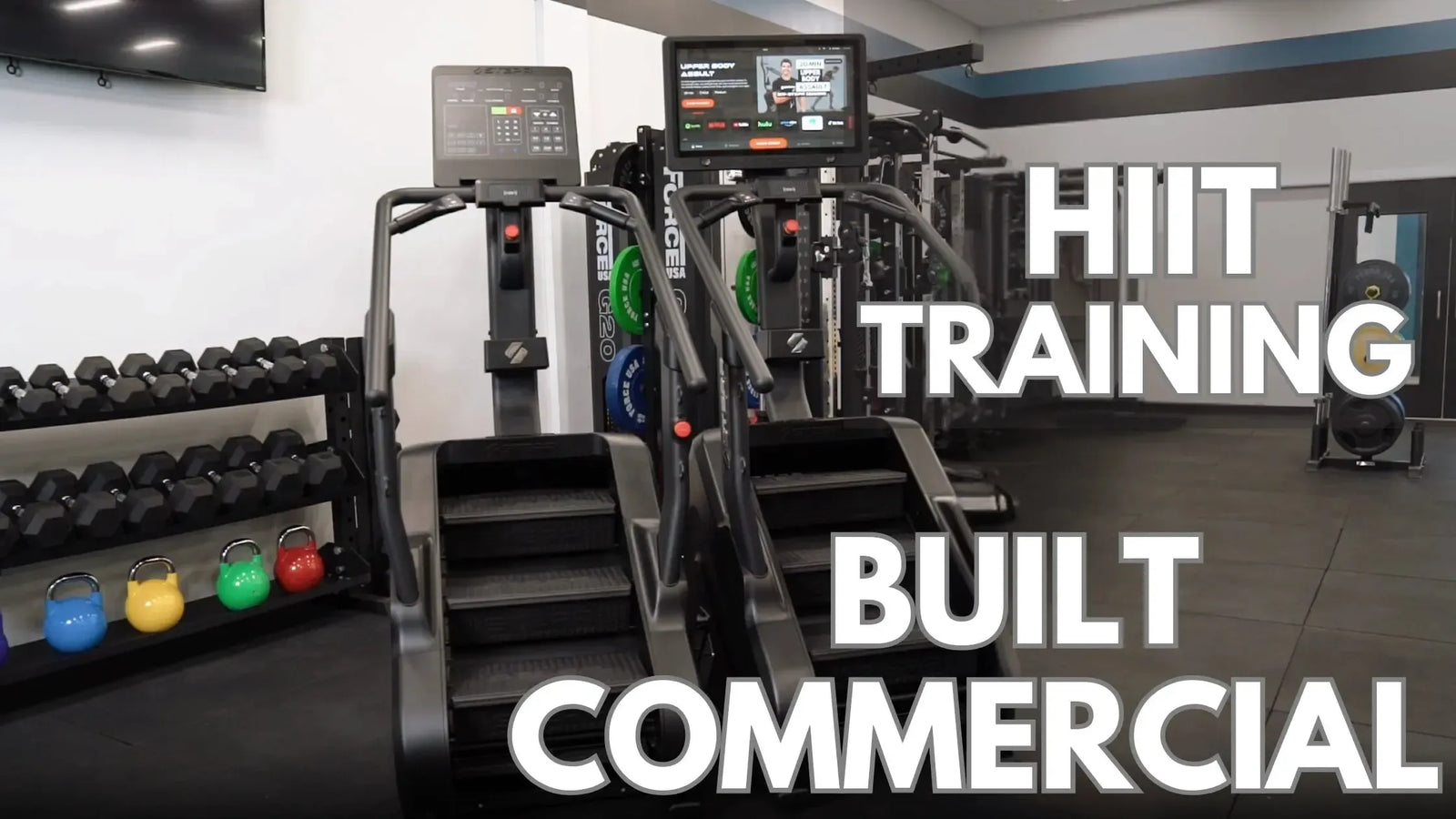 A gym with stair climber machines, colorful kettlebells on the floor, and a rack of dumbbells. Large text across the image reads HIIT Training and Built Commercial.