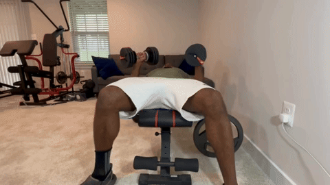 male performing a bench press with the 55 lb. NordicTrack adjustable dumbbells