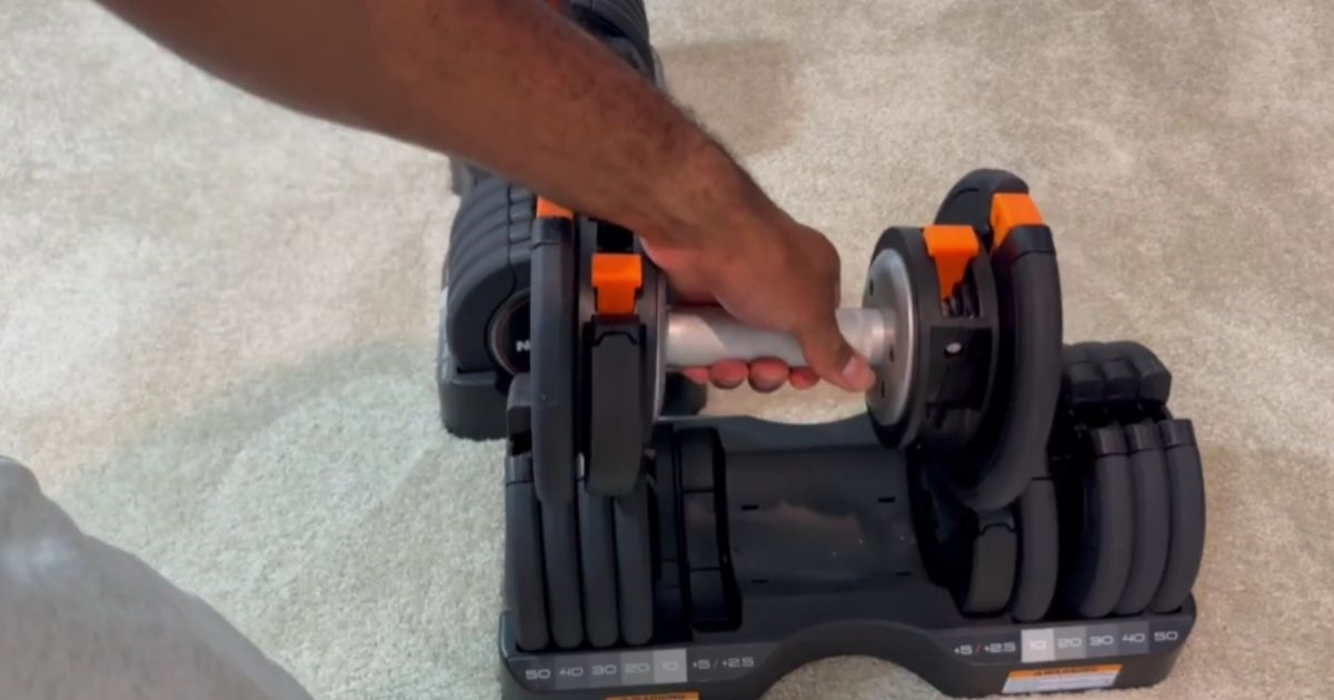 man holding NordicTrack adjustable Dumbbells with handle closeup