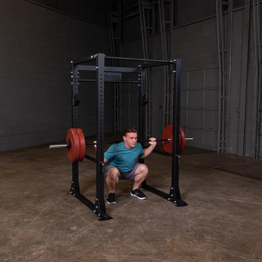 man deep squat on power rack