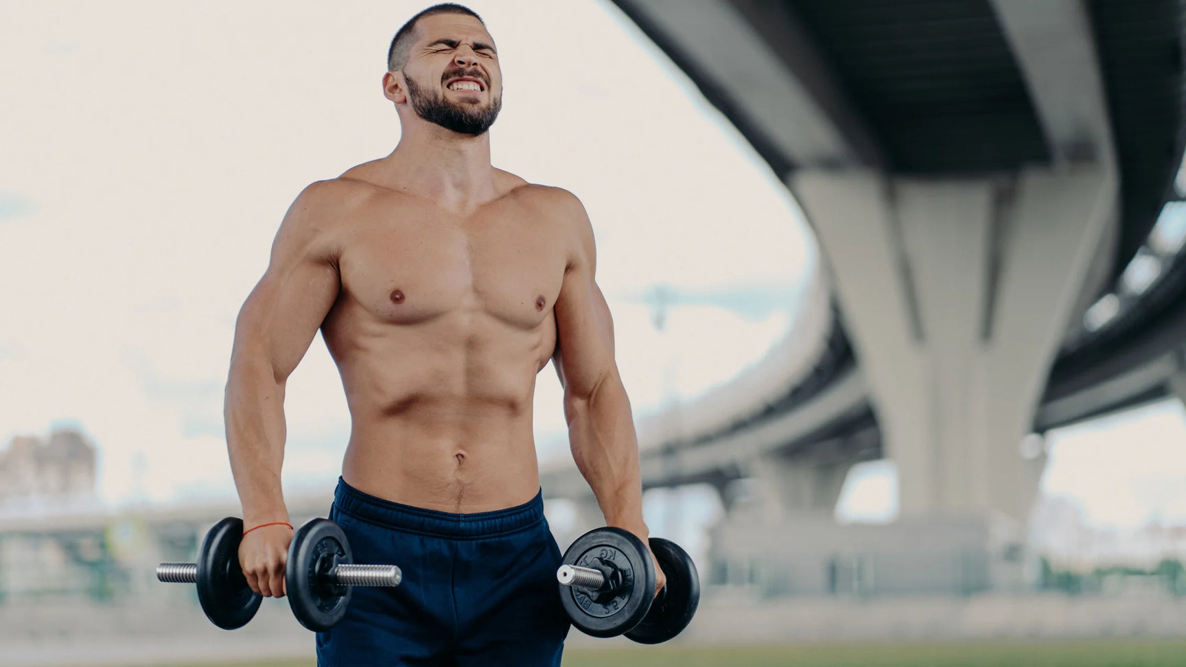 Man straining to train with dumbbells