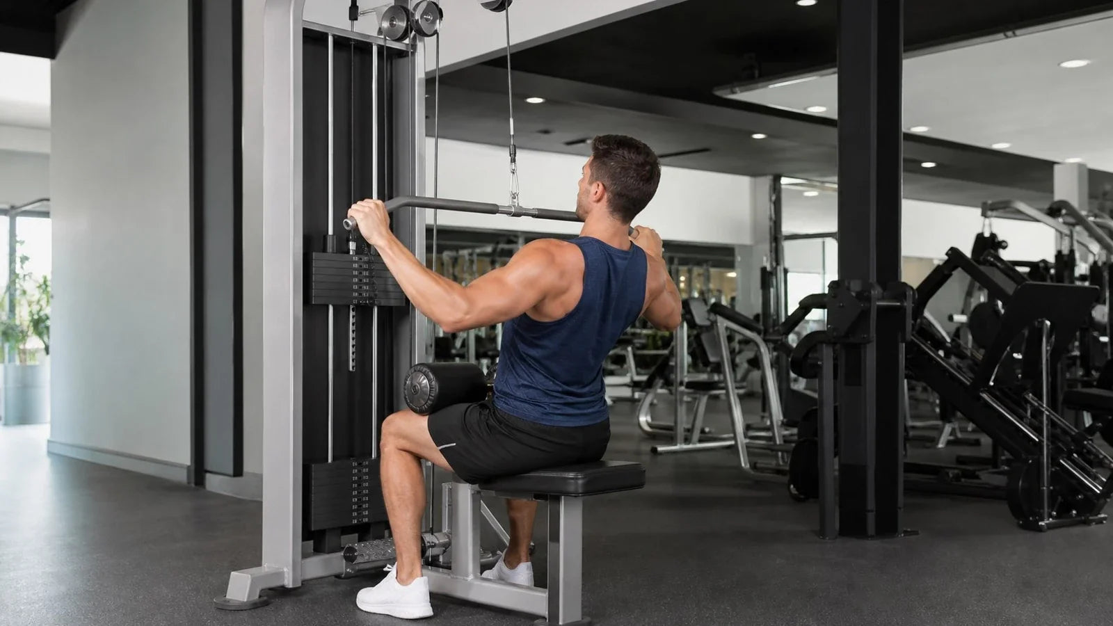 Athlete performing a seated lat pulldown in a bright gym