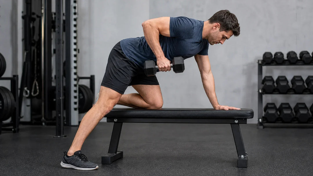 Lifter holding a braced, level torso while working with a dumbbell, the isometric position the lower back holds under load.