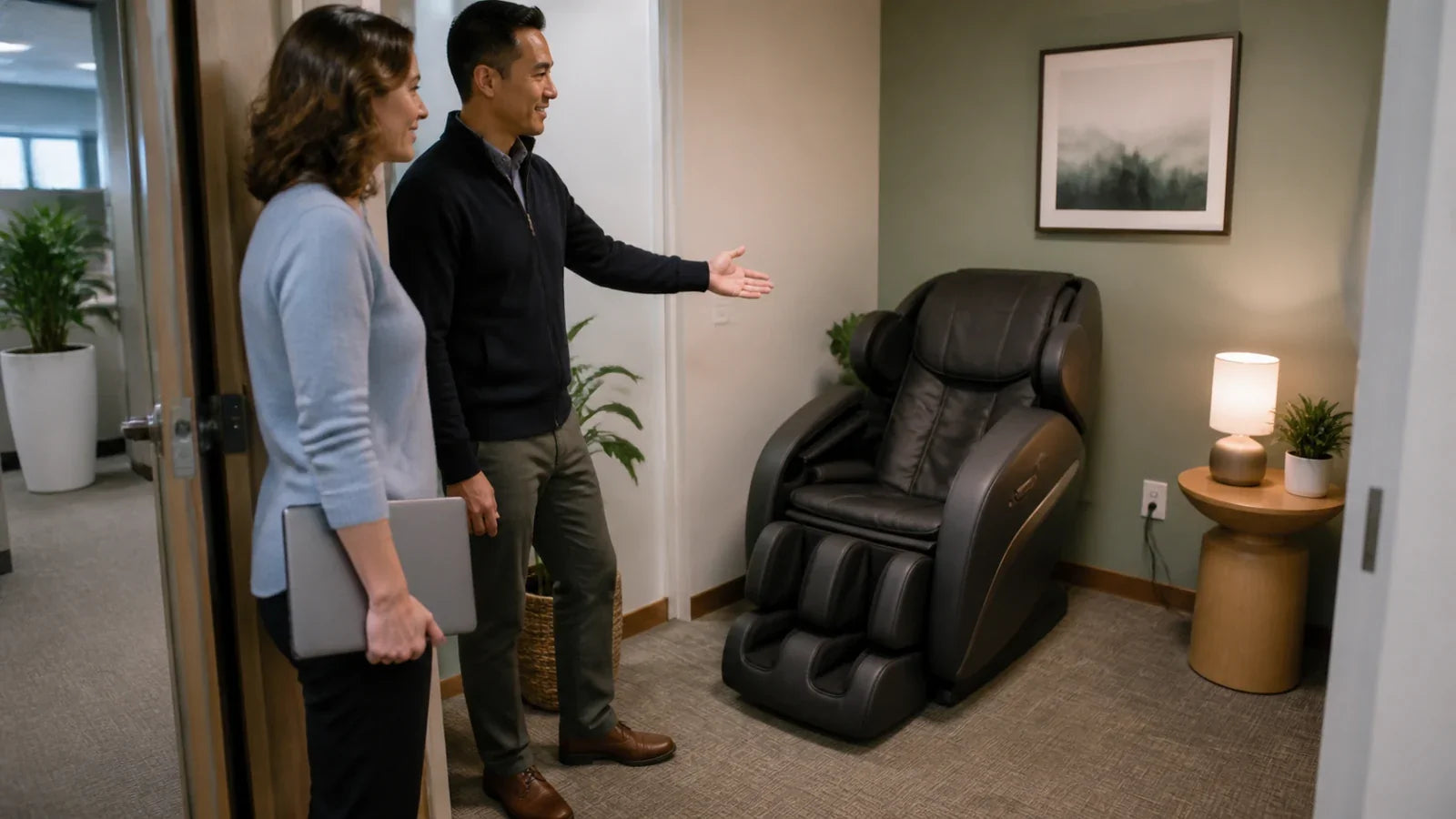 HR and facilities staff assess a private office wellness room with a massage chair and nearby outlet.