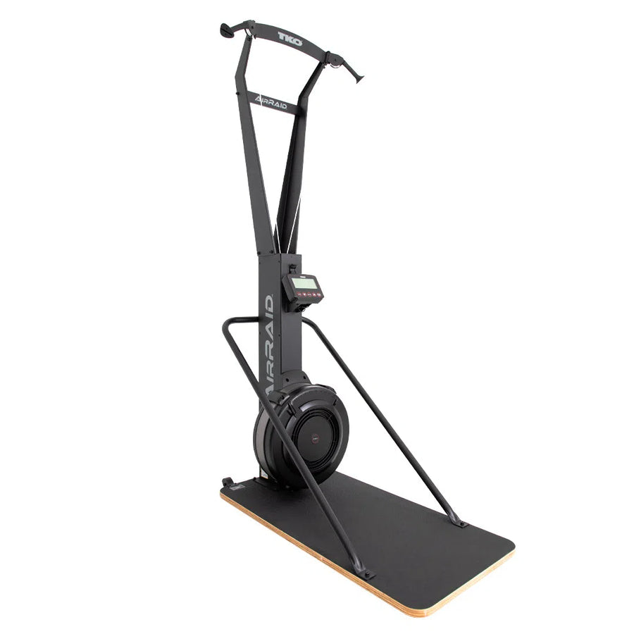 The TKO Strength AirRaid Ski Trainer (8ASKI) is a black vertical exercise machine by TKO Strength, featuring two handles, a digital display, and a base platform. Designed for indoor use, it simulates Nordic skiing with an advanced air resistance system.