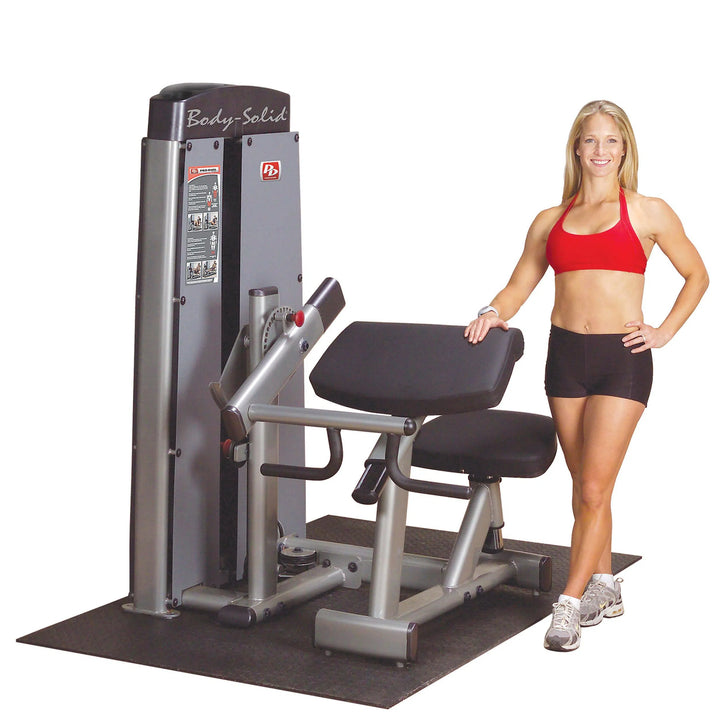 A woman showcasing the Body-Solid Bicep and Tricep Machine DBTCSF