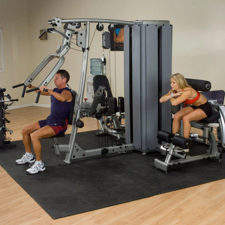 A man and woman training together on the Body-Solid Commercial Multi Station Gym DGYM