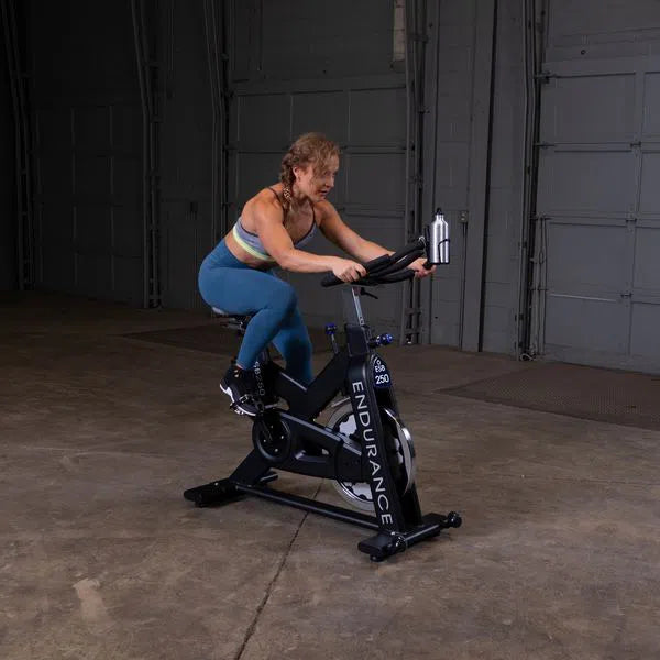 A woman training on the Body-Solid Endurance Studio Bike ESB250