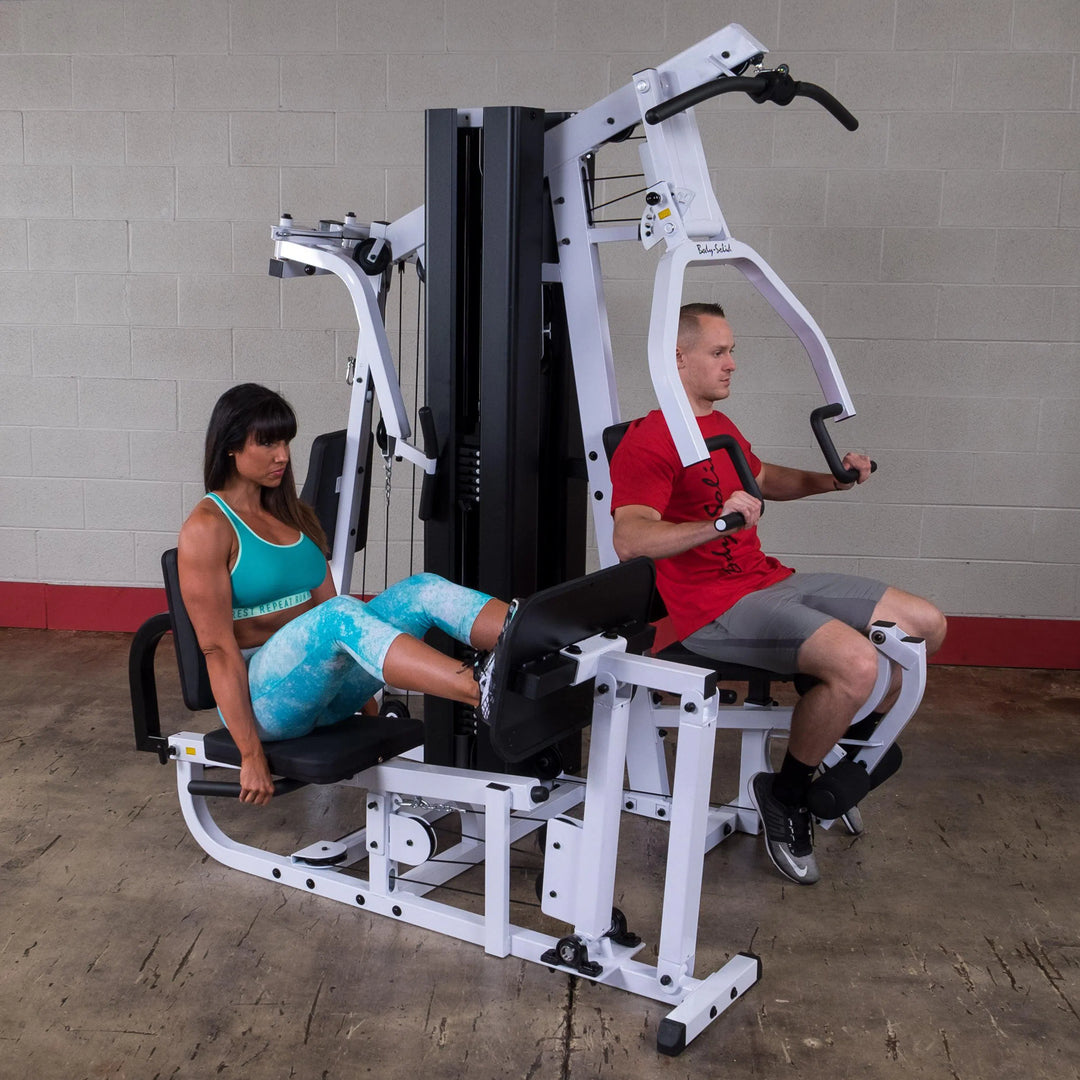 A couple workout on the Body-Solid Universal Weight Machine with Leg Press EXM3000LPS
