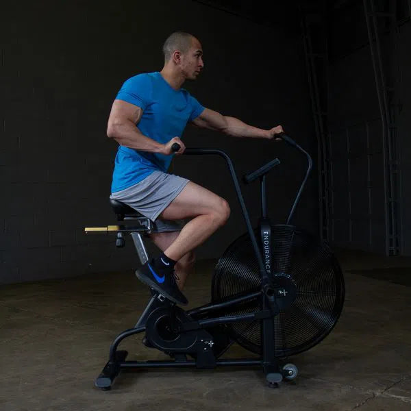 A man training on the Body-Solid Endurance Crossfit Air Bike FB300B