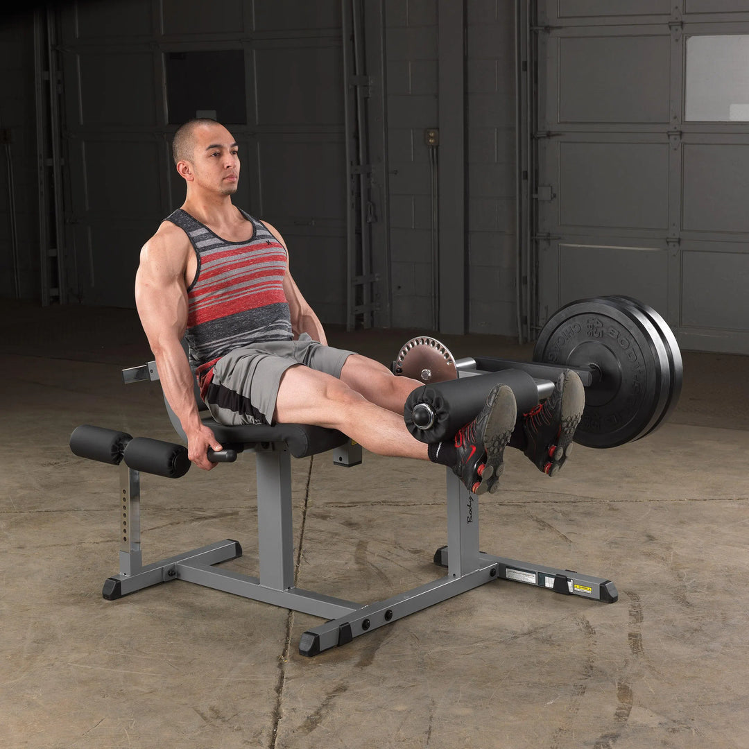 A man training on the Body-Solid Leg Extension and Curl Machine GCEC340